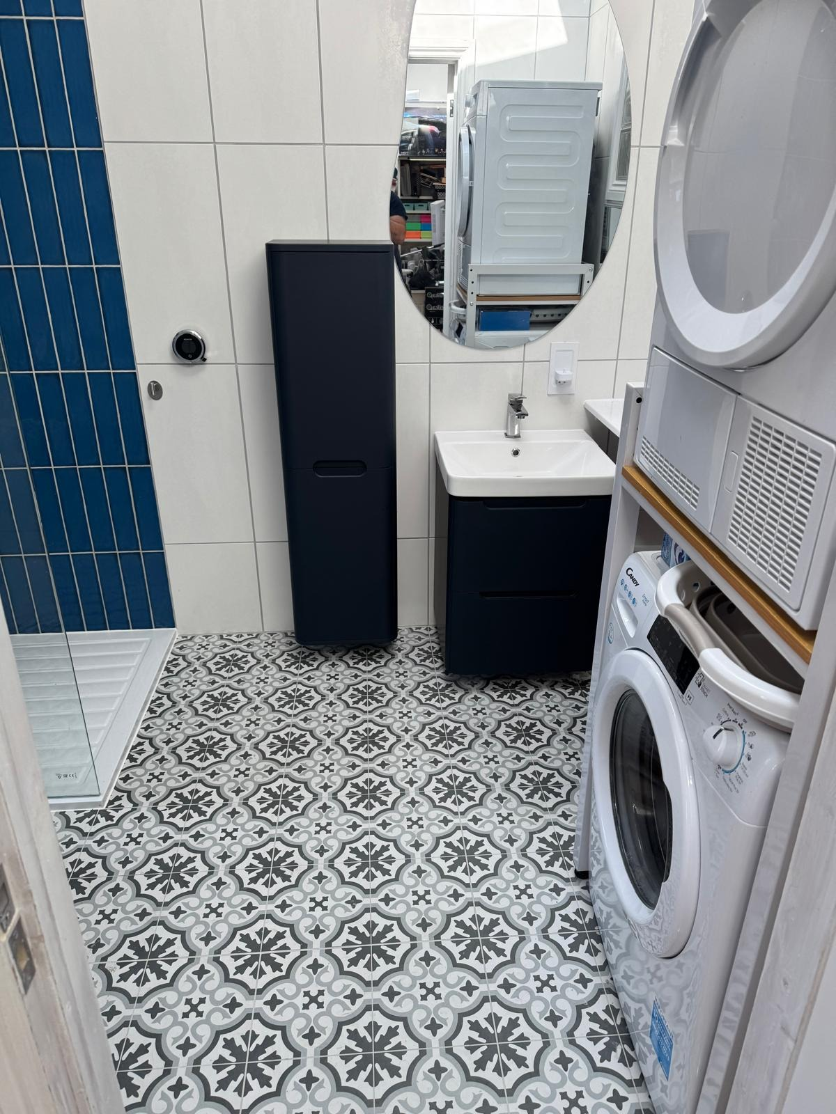 Basin, mixer tap and vanity unit plumbed in alongside a shower tray in a compact bathroom